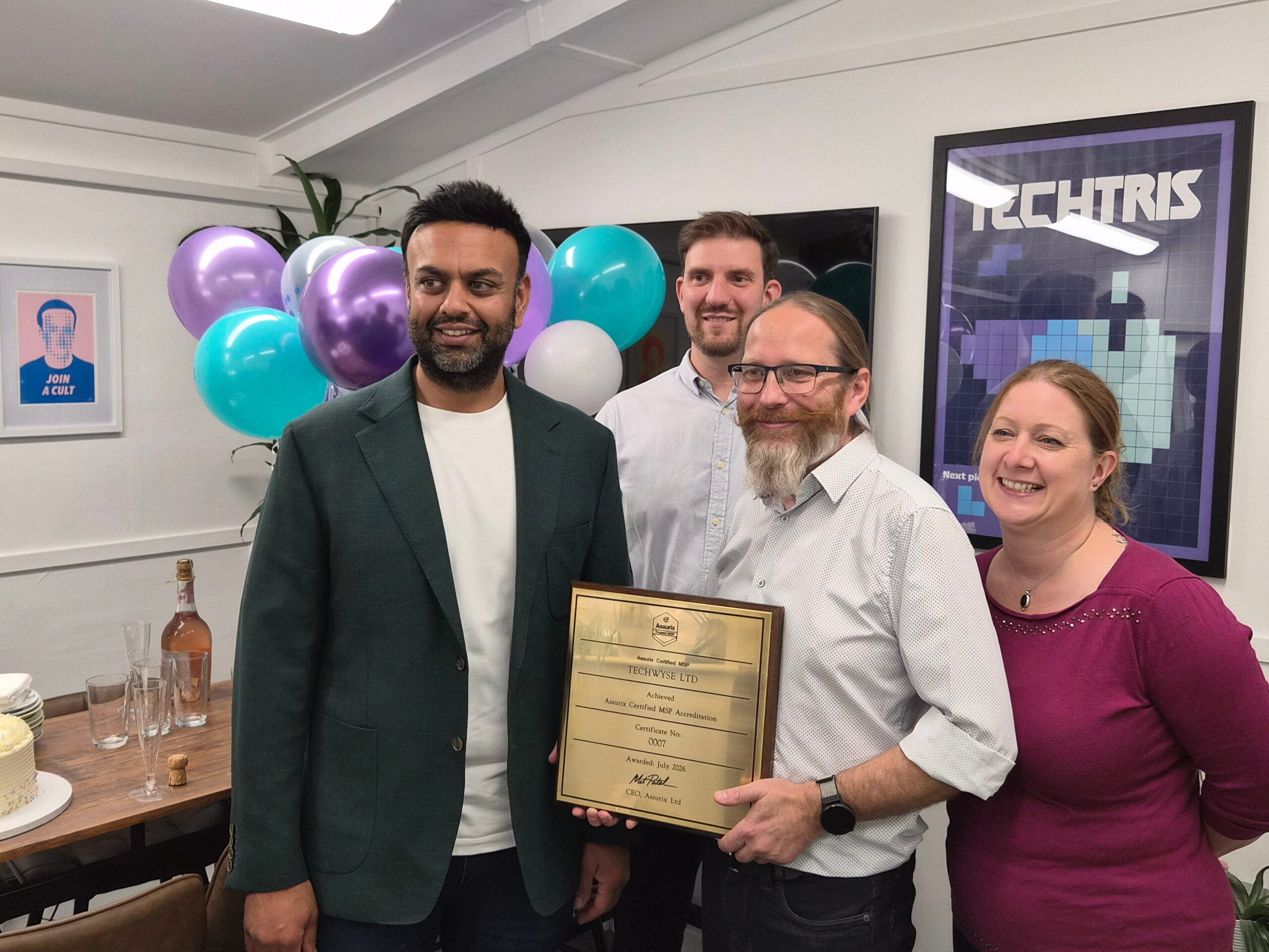 Assurix team member presents plaque to TechWyse at October Lunch & Learn
